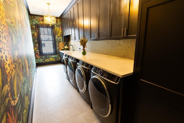 washroom with a chandelier, cabinet space, wallpapered walls, washing machine and clothes dryer, and crown molding