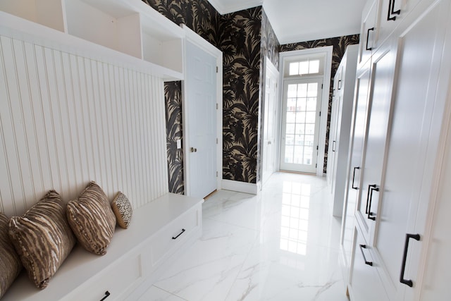 mudroom featuring baseboards, marble finish floor, and wallpapered walls