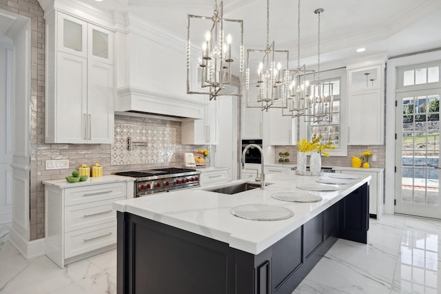 kitchen with a sink, white cabinetry, an inviting chandelier, and high end range