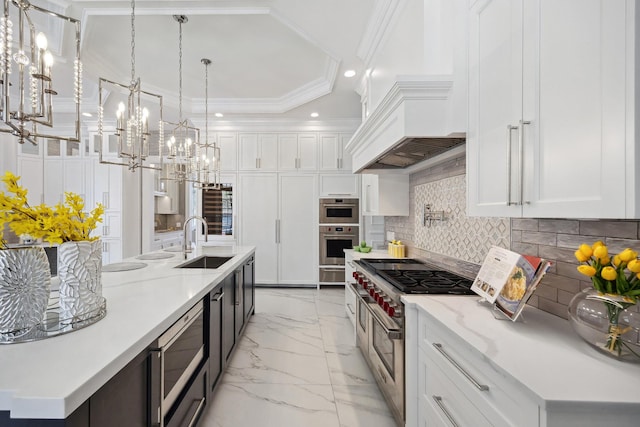 kitchen featuring recessed lighting, appliances with stainless steel finishes, marble finish floor, a sink, and a notable chandelier