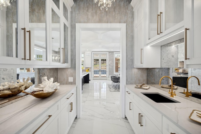 bar with a sink, marble finish floor, and coffered ceiling