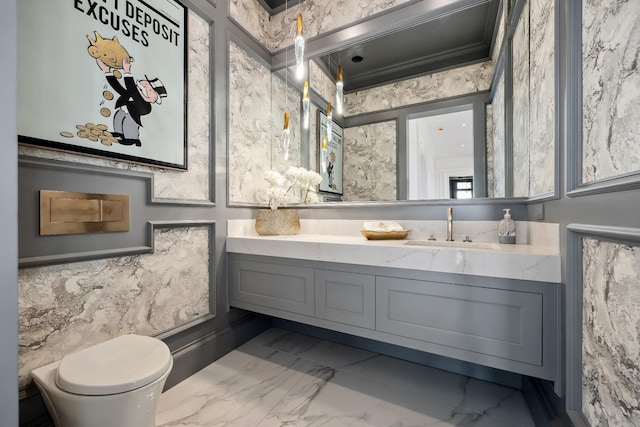 bathroom featuring toilet, marble finish floor, and vanity