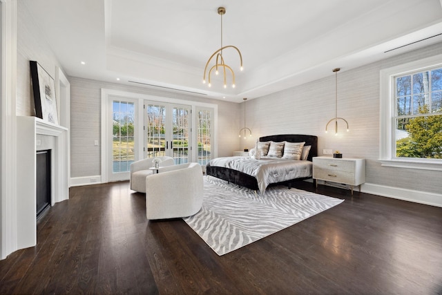 bedroom featuring multiple windows, baseboards, and access to outside