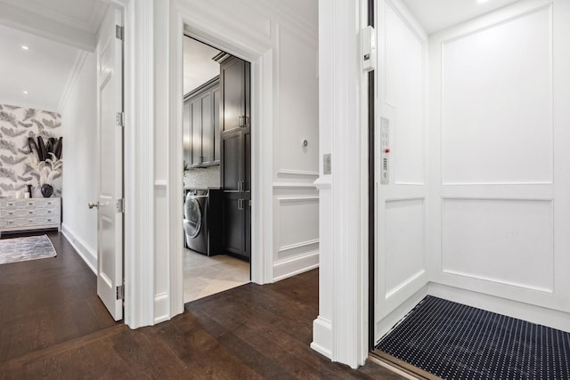 hallway featuring recessed lighting, crown molding, dark wood-type flooring, washer / dryer, and a decorative wall