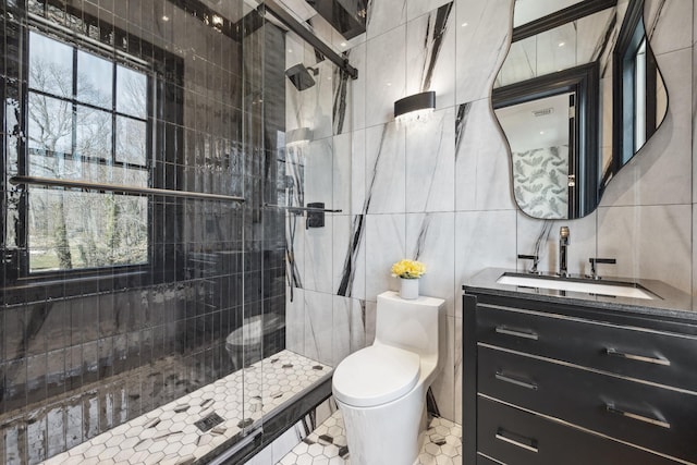 bathroom featuring vanity, tile patterned flooring, toilet, a shower stall, and tile walls