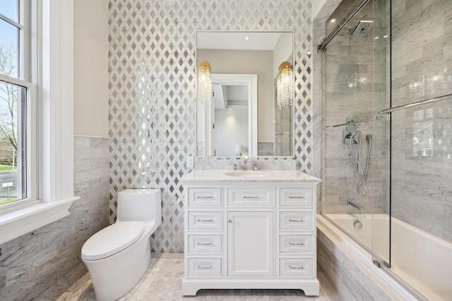 bathroom with vanity, tiled shower / bath, tile patterned flooring, toilet, and tile walls