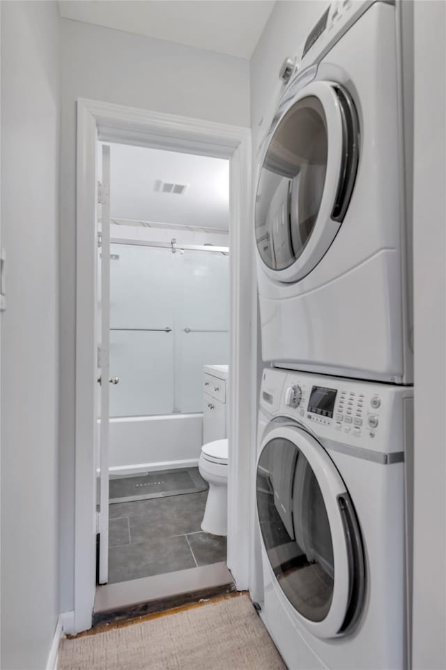 washroom featuring laundry area, visible vents, and stacked washing maching and dryer