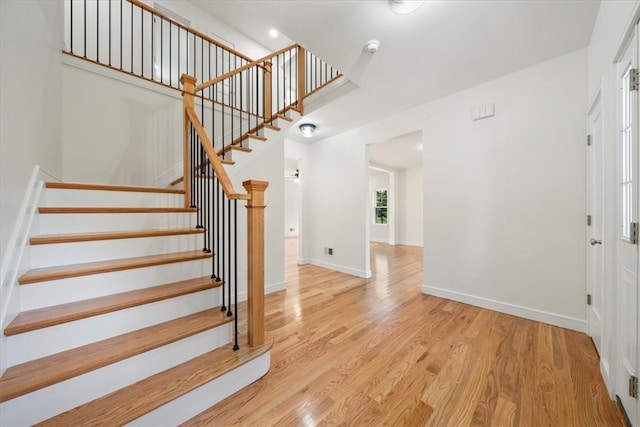 interior space with light wood-style flooring, baseboards, and stairs