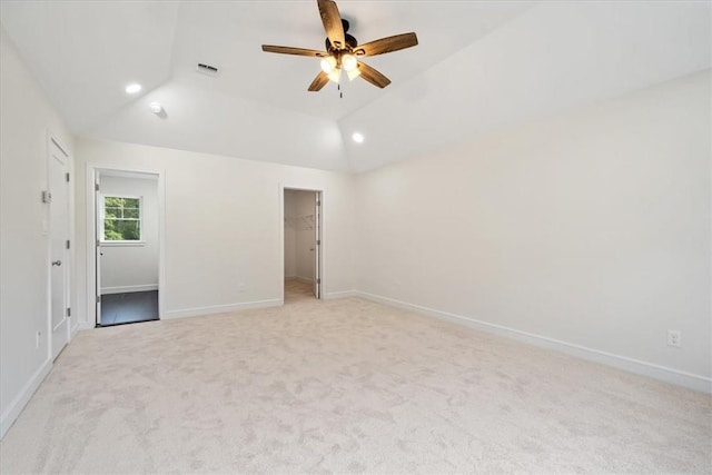 spare room featuring recessed lighting, light carpet, visible vents, baseboards, and vaulted ceiling