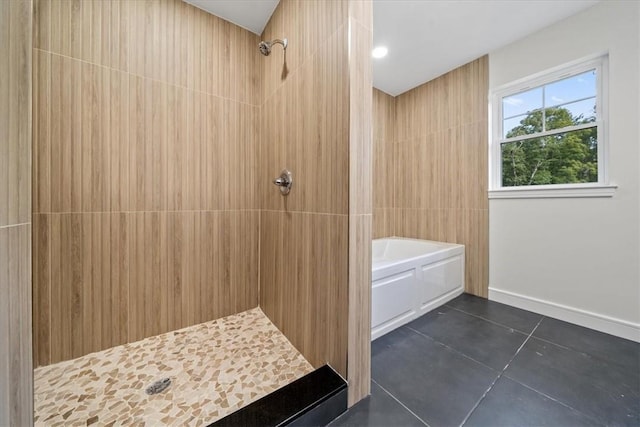 bathroom featuring baseboards, tiled shower, a bath, tile patterned flooring, and tile walls