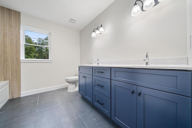 full bathroom with double vanity, toilet, a sink, tile patterned flooring, and baseboards