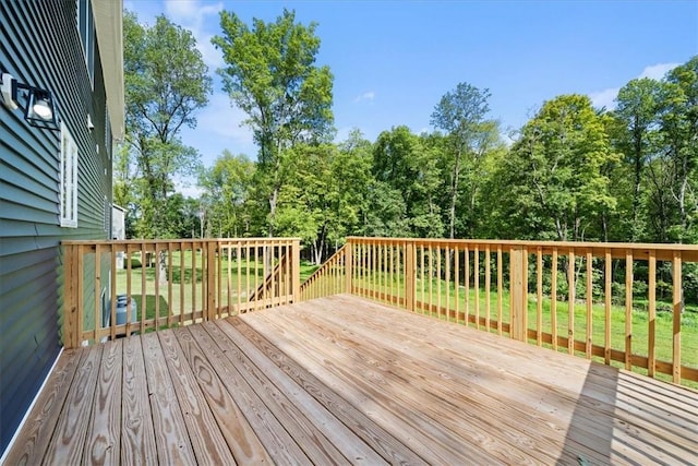 wooden deck featuring a lawn