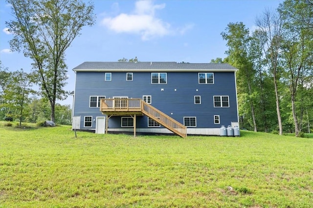 back of property with a lawn, a wooden deck, and stairs