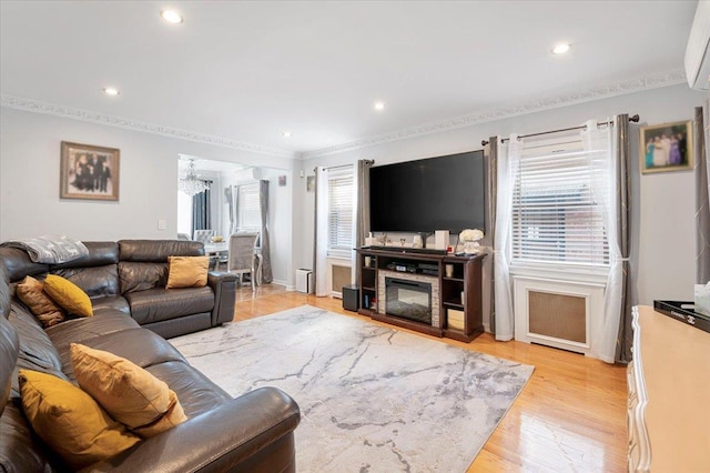 living area featuring plenty of natural light, light wood-type flooring, baseboards, and recessed lighting