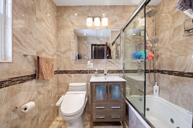 bathroom with toilet, a combined bath / shower with jetted tub, tile walls, and vanity