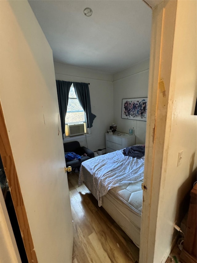 bedroom with cooling unit and light wood-style floors