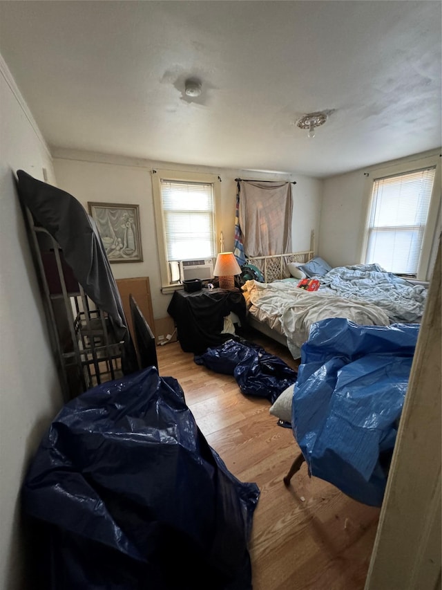 bedroom featuring cooling unit and wood finished floors