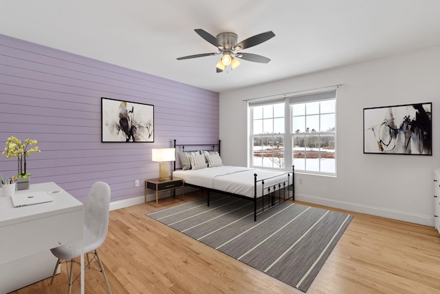 61 Surrey St, Rock Hill, NY 12775 - bedroom featuring baseboards, light wood-style flooring, a desk, a ceiling fan, and wood walls