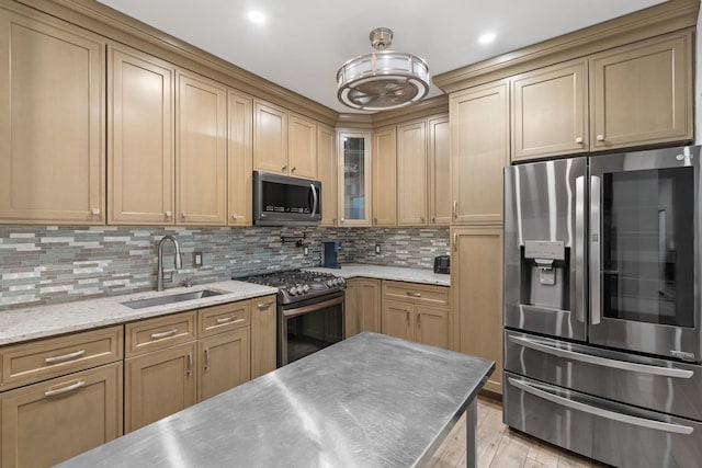 kitchen featuring a sink, appliances with stainless steel finishes, light wood-type flooring, backsplash, and glass insert cabinets