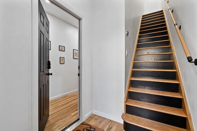 stairs with baseboards and wood finished floors