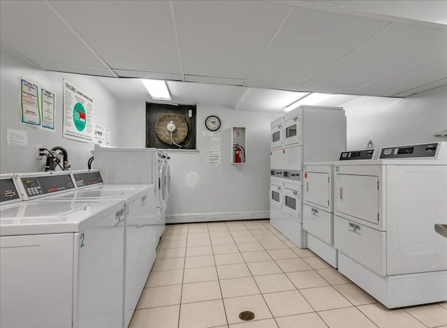 common laundry area featuring stacked washer / dryer, washer and clothes dryer, and light tile patterned floors