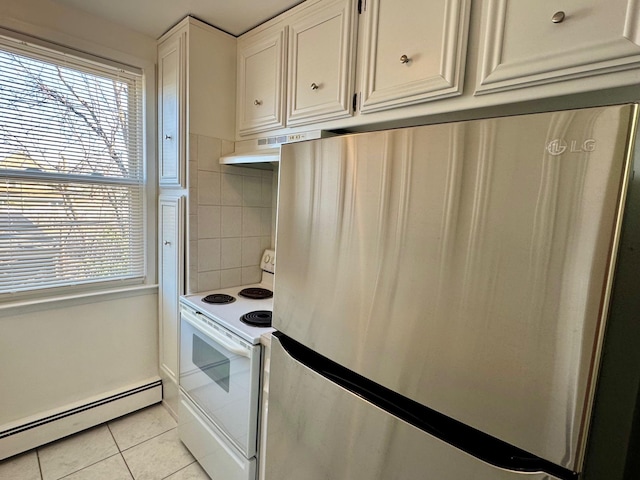 kitchen with white electric stove, light tile patterned floors, a baseboard heating unit, freestanding refrigerator, and plenty of natural light