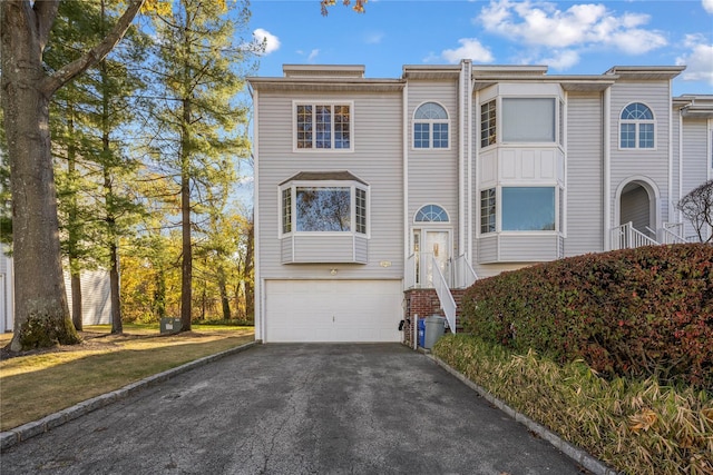 view of property featuring a garage and aphalt driveway