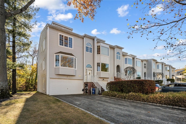 view of property featuring driveway, an attached garage, and a residential view