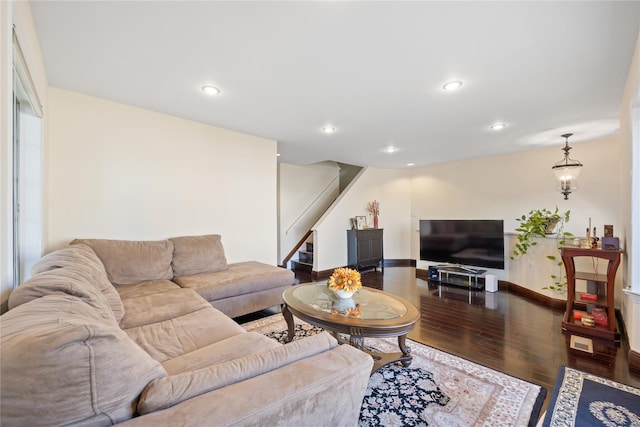 living area featuring baseboards, wood finished floors, an inviting chandelier, stairs, and recessed lighting