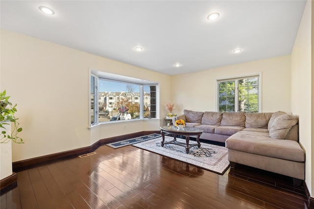 living area with visible vents, baseboards, wood finished floors, and recessed lighting