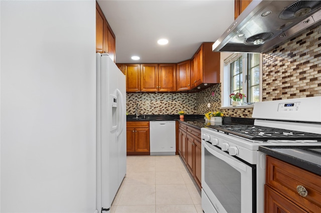 kitchen featuring white appliances, a sink, custom exhaust hood, decorative backsplash, and brown cabinetry