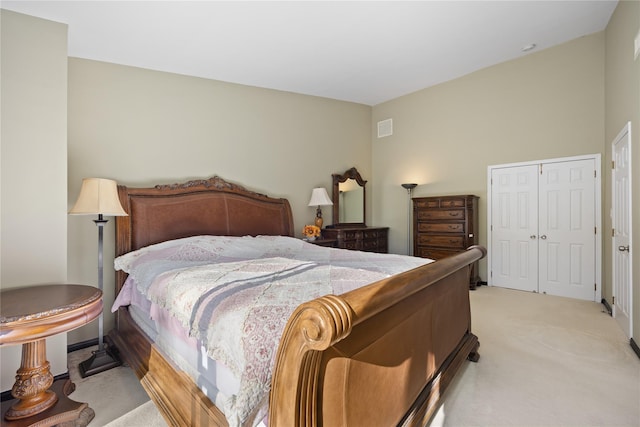 bedroom with light carpet, visible vents, and a closet