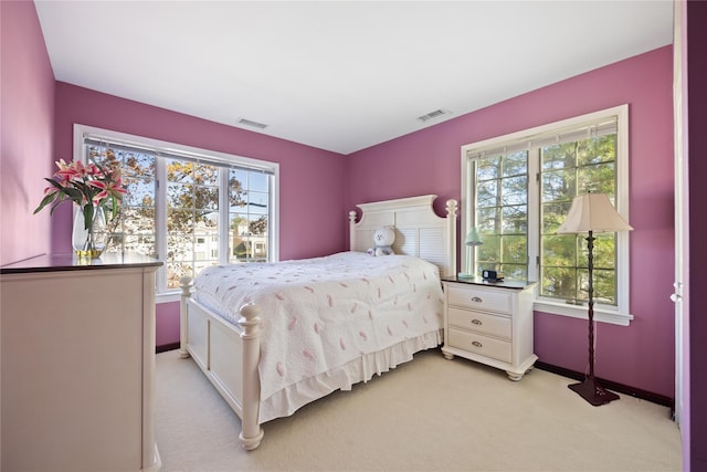 bedroom with visible vents and light carpet