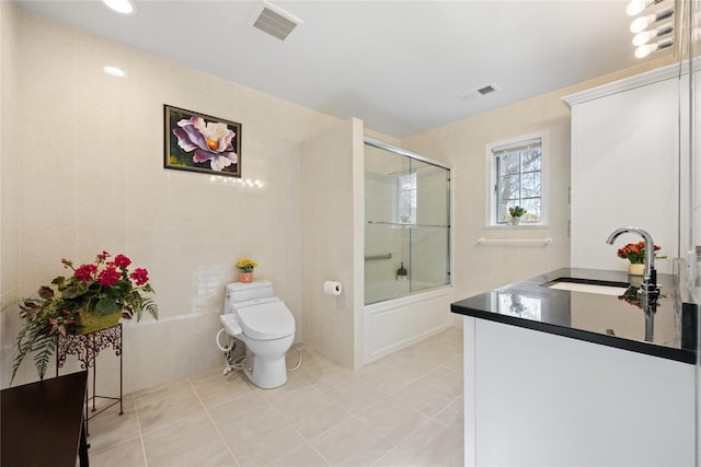 bathroom featuring tile walls, visible vents, vanity, and toilet