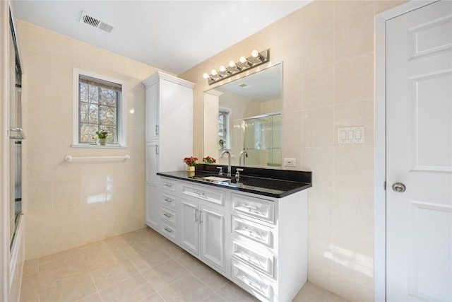 full bathroom with visible vents, tile patterned flooring, vanity, and tile walls