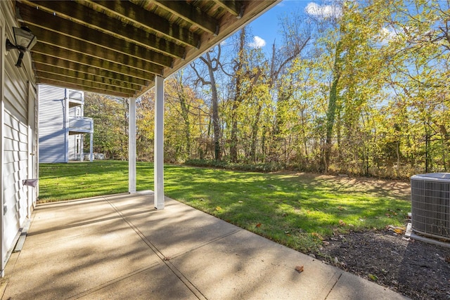 view of yard with a patio area, fence, and central AC