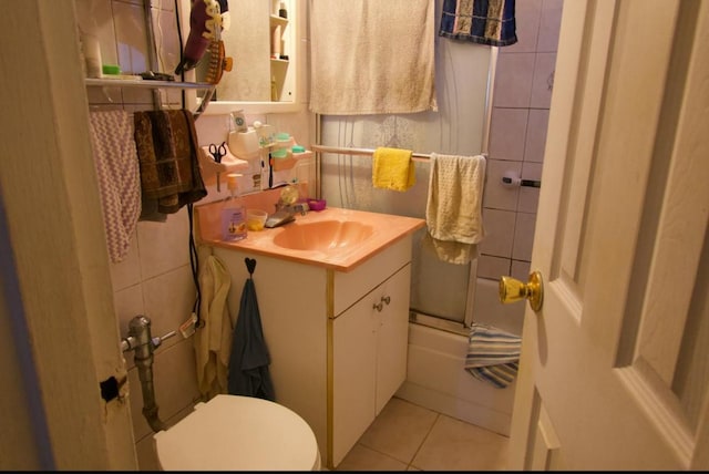 full bathroom with enclosed tub / shower combo, toilet, vanity, and tile patterned floors