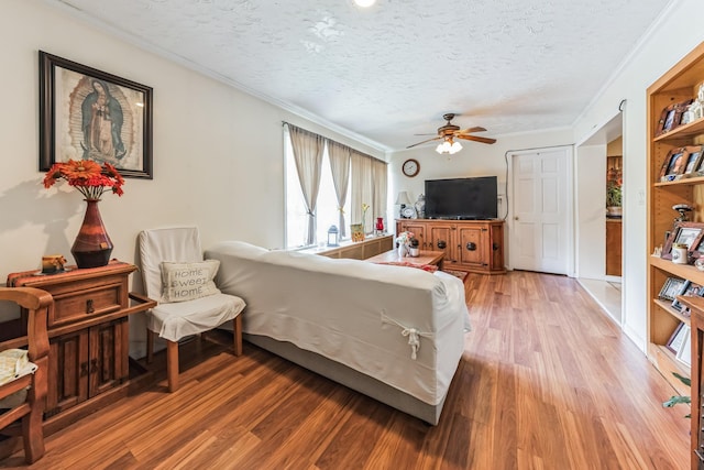 bedroom featuring ceiling fan, crown molding, a textured ceiling, and wood finished floors