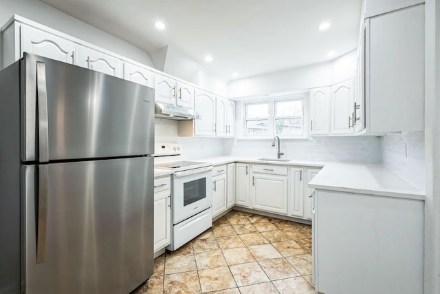 kitchen with white range with electric cooktop, white cabinets, freestanding refrigerator, under cabinet range hood, and a sink