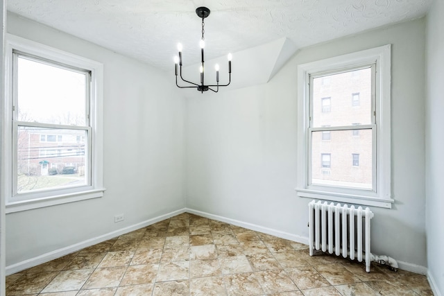 unfurnished dining area featuring radiator, baseboards, and a textured ceiling