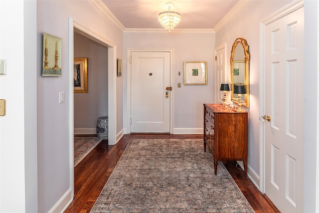 foyer entrance featuring dark wood-type flooring, a chandelier, crown molding, and baseboards