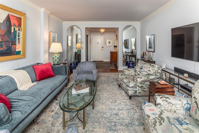 living area featuring arched walkways, ornamental molding, and wood finished floors