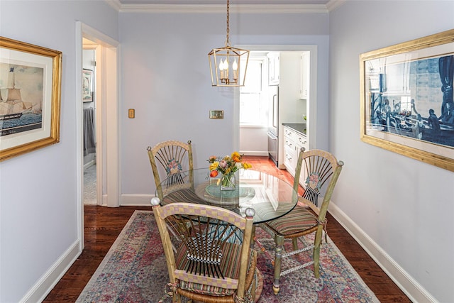 dining space featuring crown molding, a notable chandelier, and wood finished floors