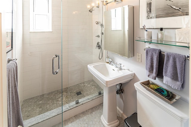 bathroom with a wealth of natural light, a stall shower, and toilet