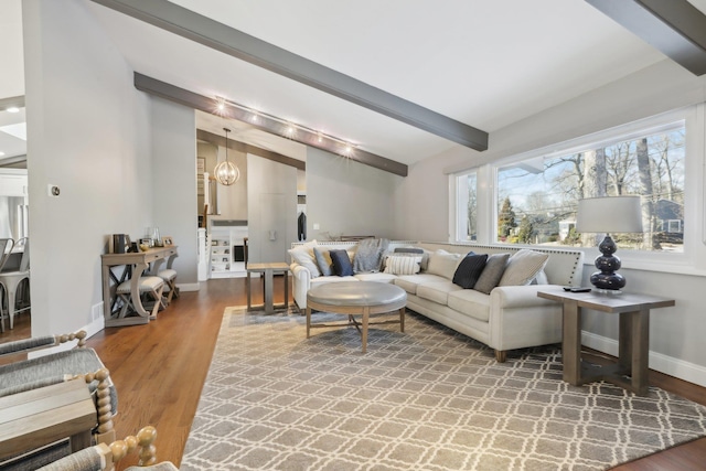 living room with lofted ceiling with beams, a notable chandelier, baseboards, and wood finished floors