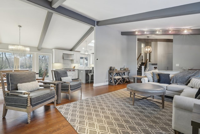 living room featuring dark wood-style floors, a notable chandelier, stairway, and lofted ceiling with beams