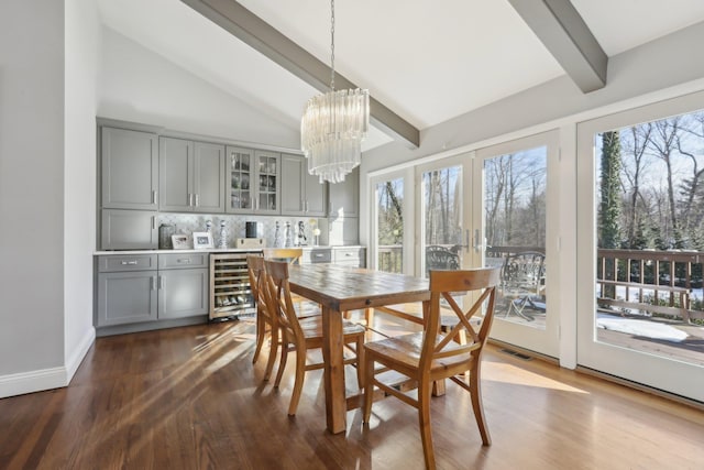 dining space featuring lofted ceiling with beams, wine cooler, visible vents, and a wealth of natural light