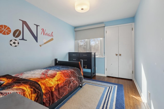 bedroom featuring a closet, baseboards, and dark wood-style flooring