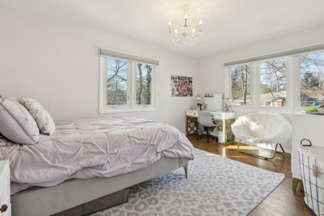 bedroom featuring wood finished floors and a notable chandelier