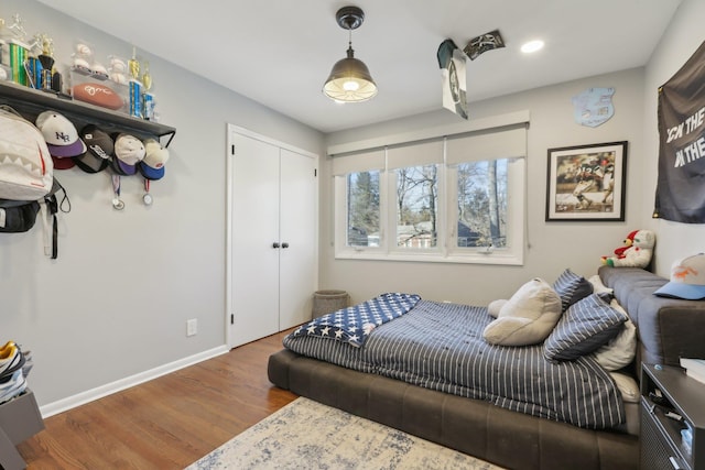 bedroom with a closet, baseboards, and wood finished floors